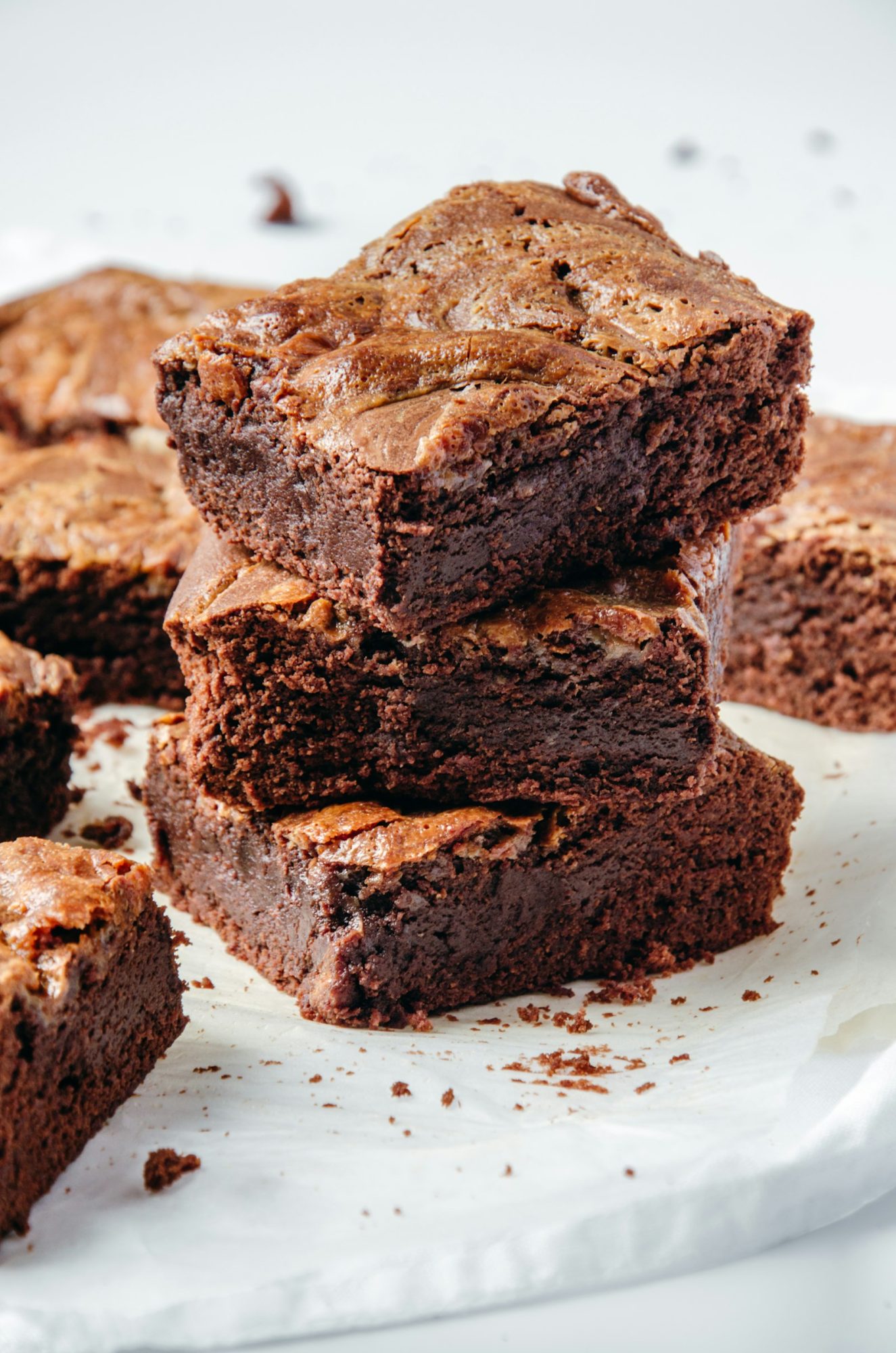 Stack of fudgy chocolate brownies on a white plate